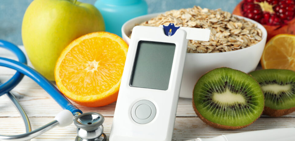Blood glucose meter and diabetic food on wooden table