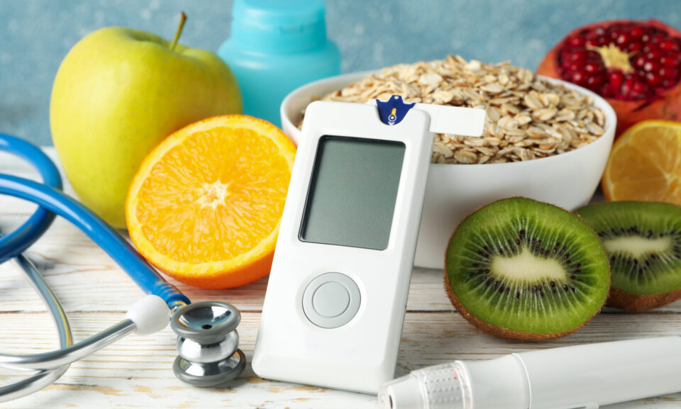 Blood glucose meter and diabetic food on wooden table