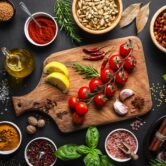 Culinary backgrounds: Group of spices, herbs and cooking ingredients shot from above on black background. Flat lay border or copy space